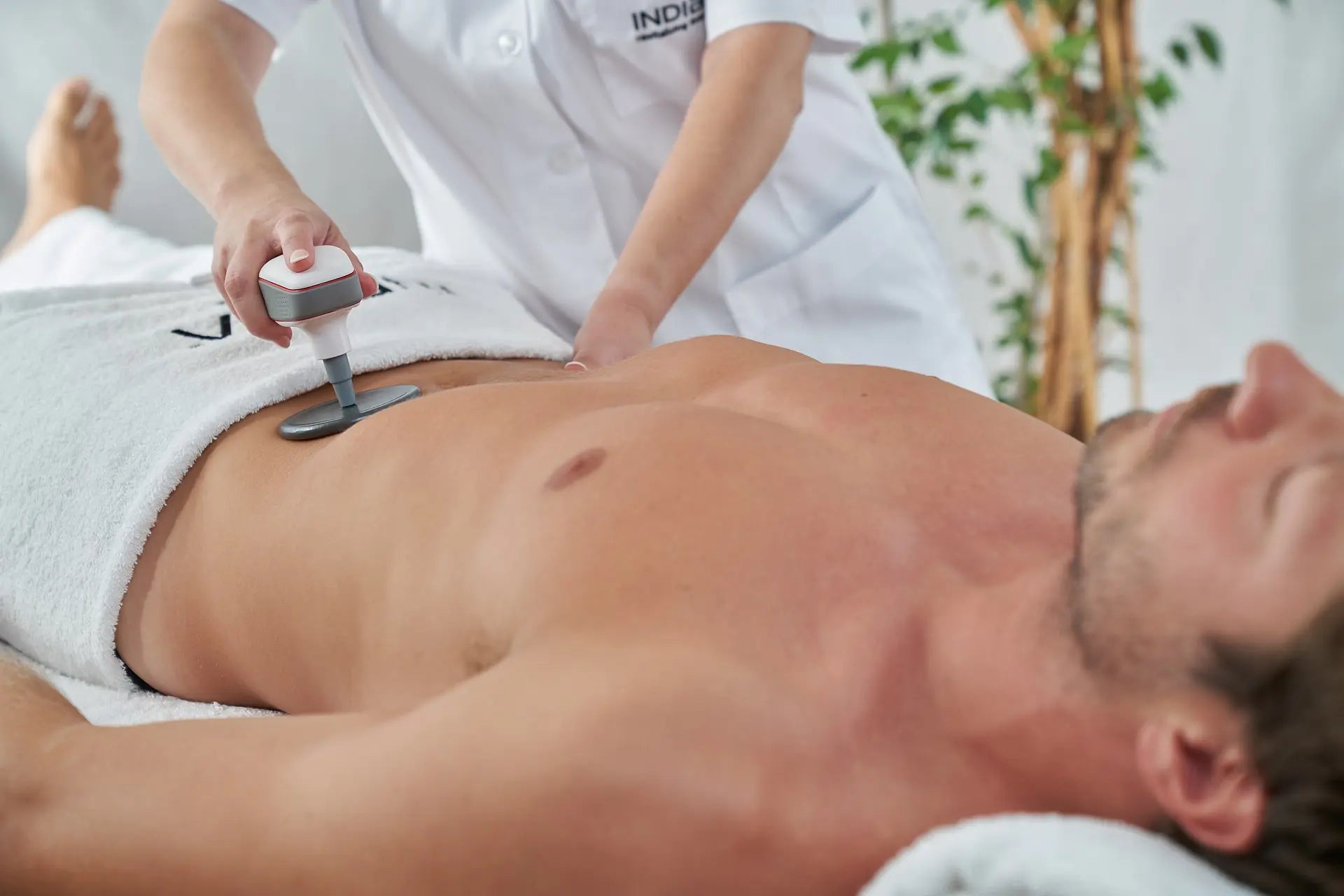 Hombre relajado recibiendo tratamiento corporal de indiba en Glo&Beauty.