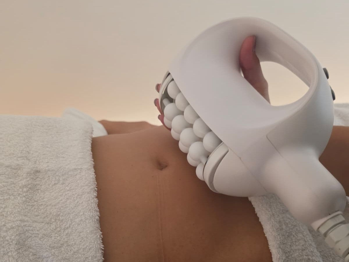 Aplicación del cabezal Slaag Motion BIOSPHERE sobre el abdomen durante una sesión real en Studio Glo&Beauty, Badalona