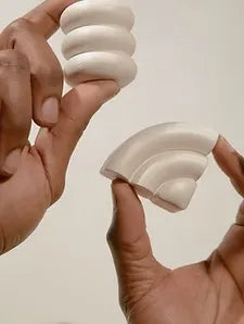 Dos manos que agarran un objeto blanco, simbolizando cuidado y atención hacia el objeto en cuestión.